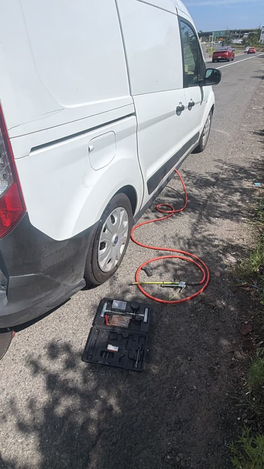 Service van parked roadside with air hose and tools out