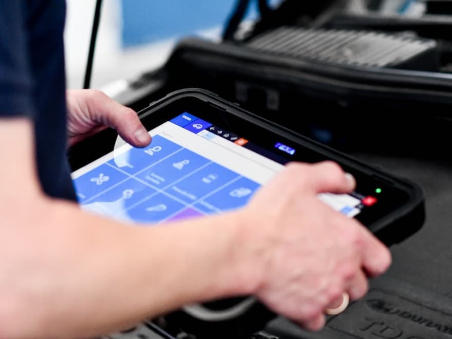 Technician running an OBD-II diagnostic scan on a vehicle