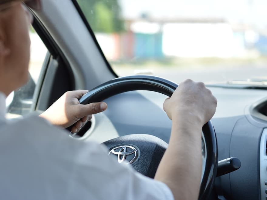Driver holding the steering wheel of a car